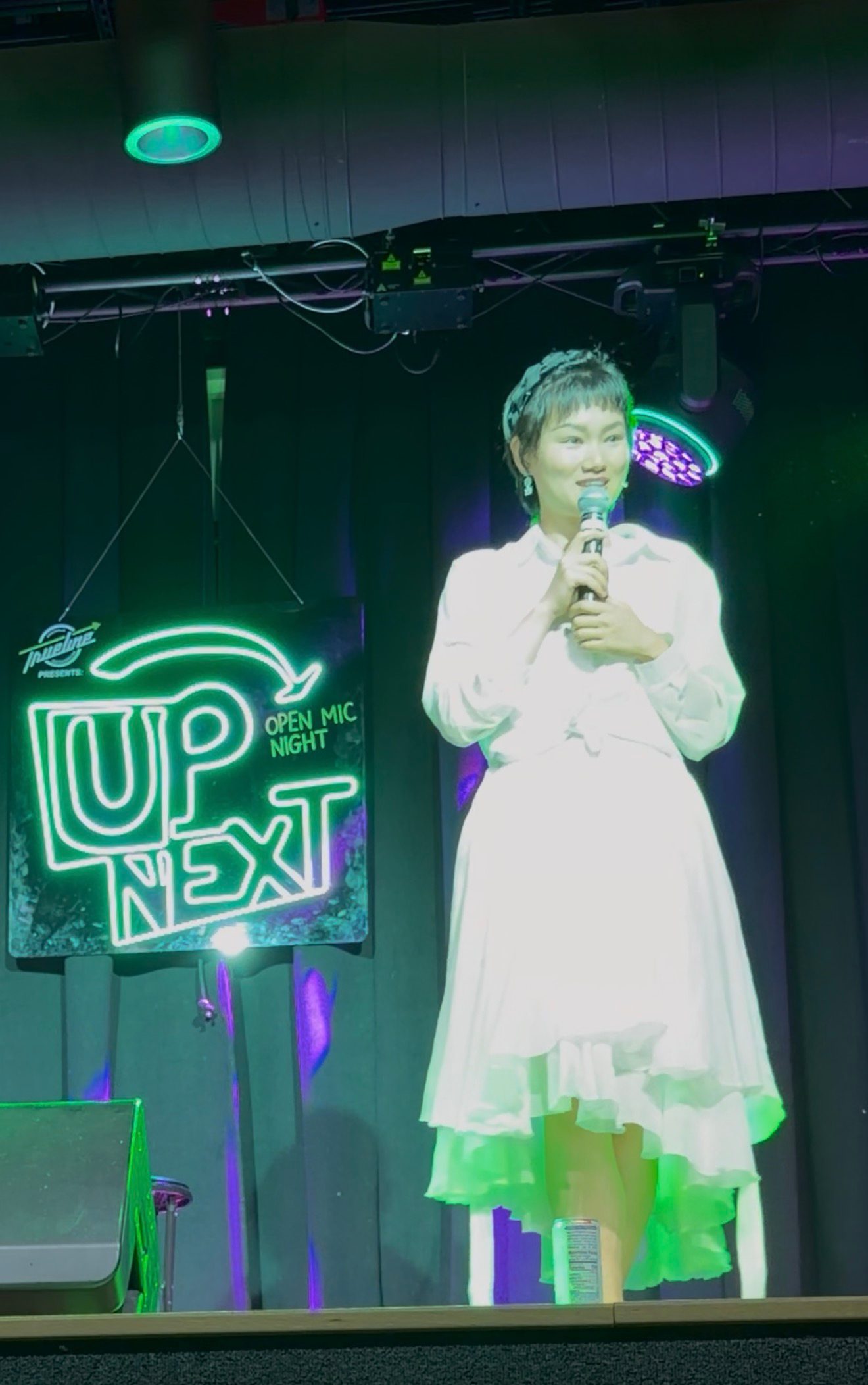 Ginger Phoenix performing under an Up Next neon sign