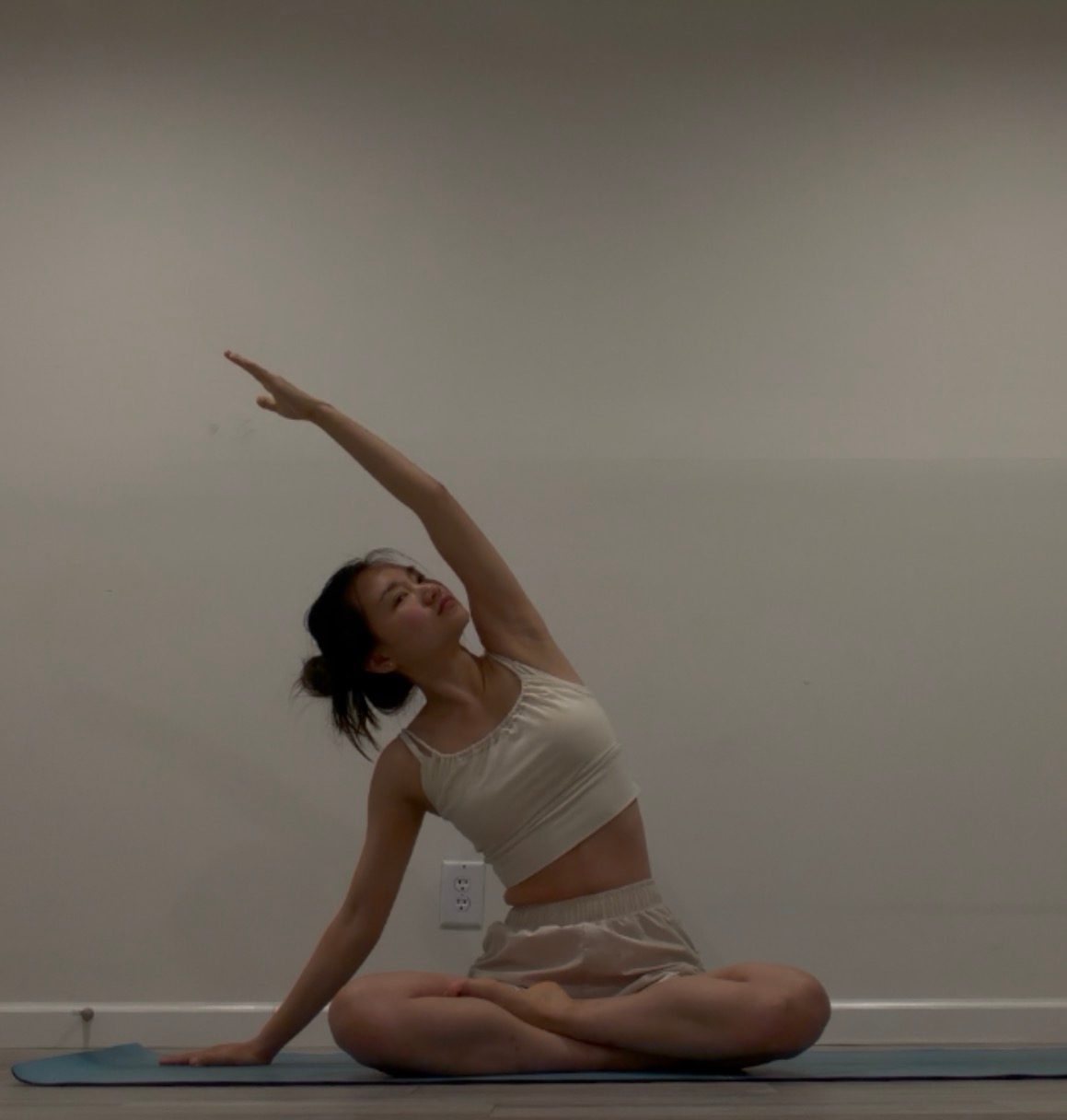 Ginger Phoenix in a yoga pose, silhouetted against a bright studio wall
